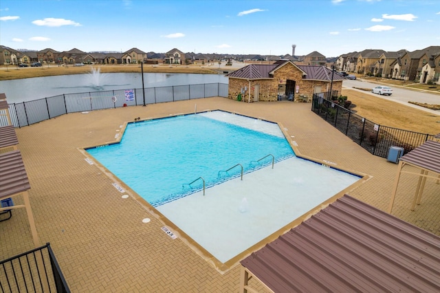 view of pool featuring a patio and a water view