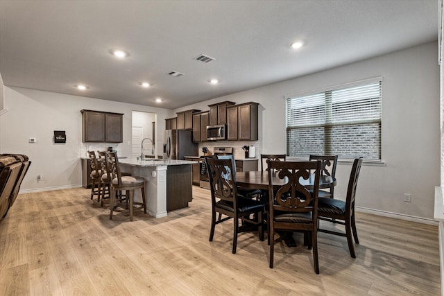 dining room featuring sink and light wood-type flooring