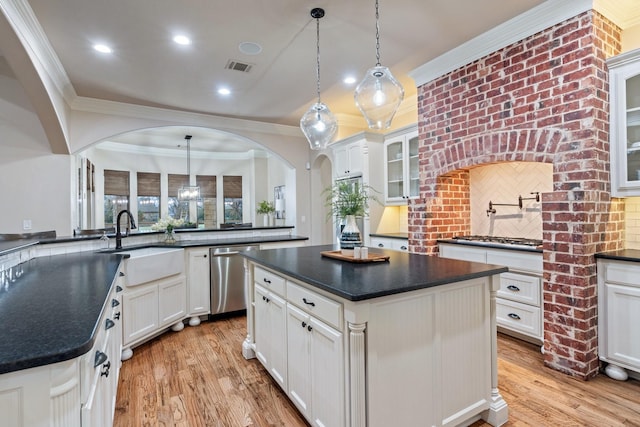 kitchen with a kitchen island, stainless steel dishwasher, and pendant lighting