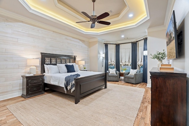 bedroom featuring crown molding, ceiling fan, a raised ceiling, and light hardwood / wood-style floors