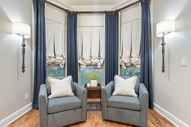 living area featuring hardwood / wood-style flooring and ornamental molding