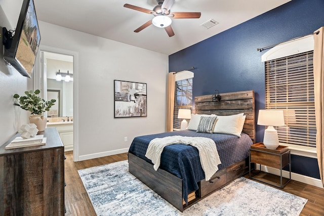 bedroom with sink, ensuite bath, dark wood-type flooring, and ceiling fan