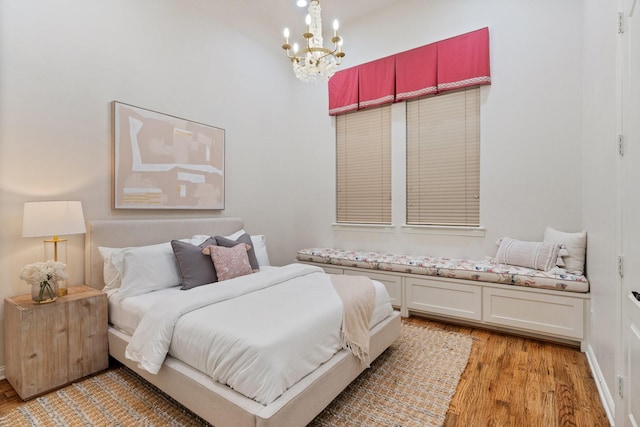 bedroom with an inviting chandelier and light hardwood / wood-style floors