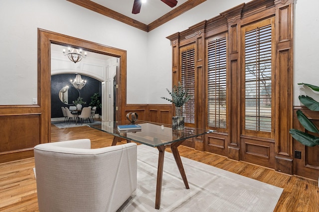 office space with crown molding, ceiling fan with notable chandelier, and hardwood / wood-style flooring