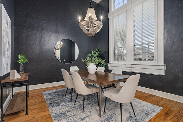 dining room with hardwood / wood-style floors and a notable chandelier