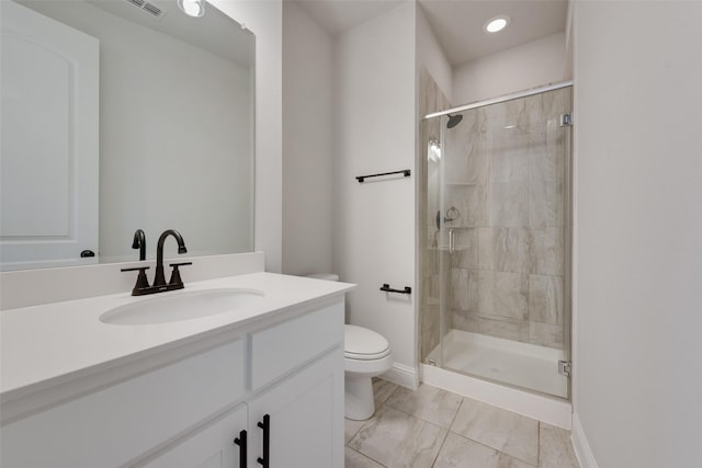 bathroom featuring vanity, toilet, and a shower with shower door