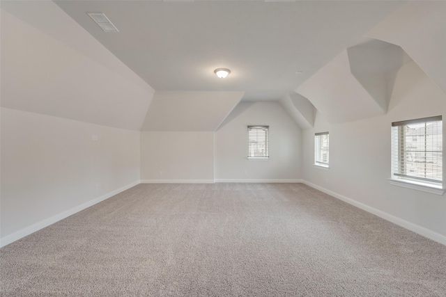 additional living space with carpet floors and vaulted ceiling