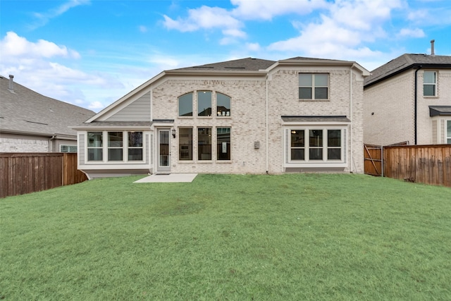 rear view of property featuring a lawn