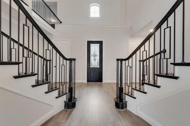 foyer entrance with hardwood / wood-style flooring and a towering ceiling