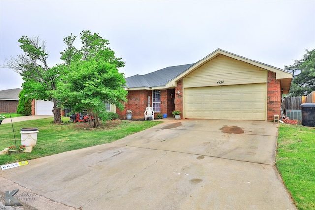 ranch-style house with a garage, a front yard, and central air condition unit