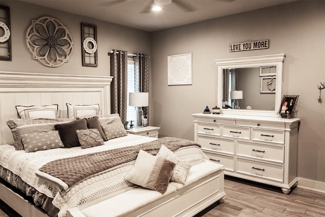 bedroom with light wood-style floors, a ceiling fan, and baseboards