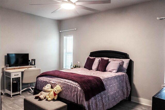 bedroom with baseboards, ceiling fan, and wood finished floors