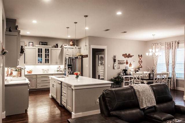 kitchen with appliances with stainless steel finishes, an inviting chandelier, a sink, light countertops, and recessed lighting