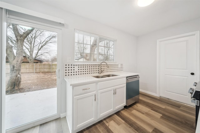 kitchen featuring dishwasher, sink, white cabinets, and light wood-type flooring