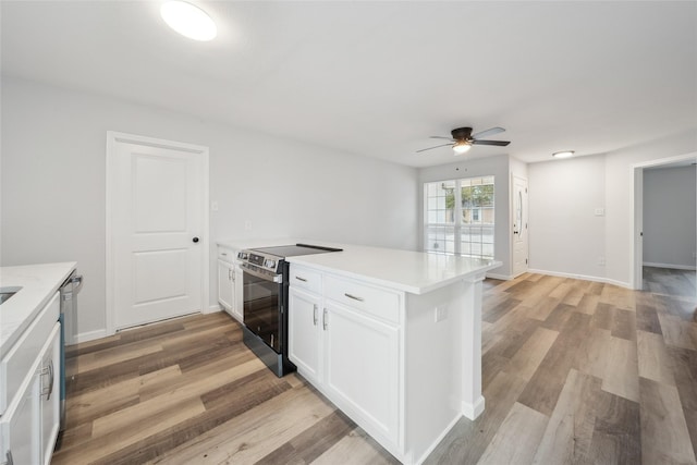 kitchen featuring ceiling fan, stainless steel electric stove, light hardwood / wood-style floors, and white cabinets