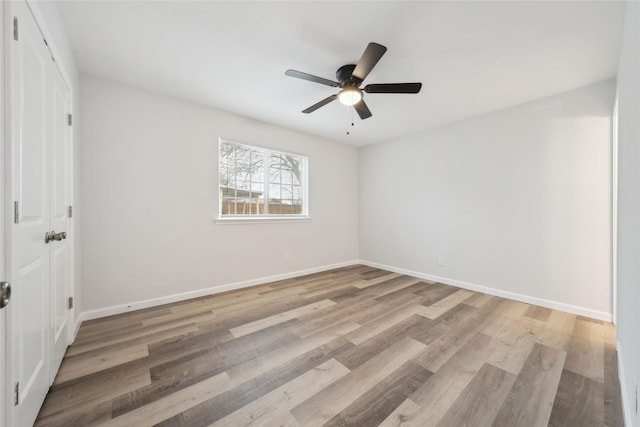 spare room with ceiling fan and light wood-type flooring