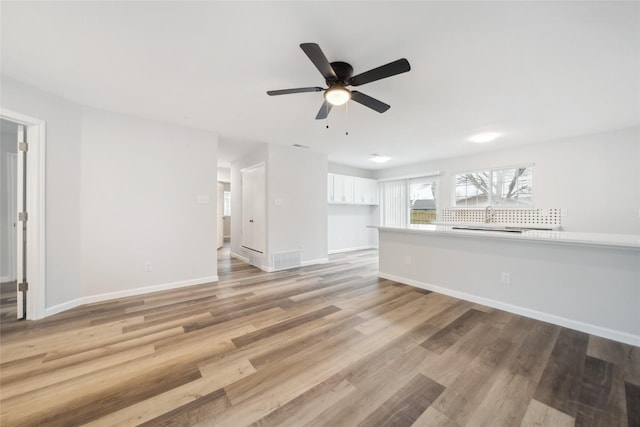 unfurnished living room with ceiling fan and light wood-type flooring