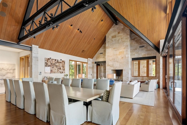 dining area with hardwood / wood-style flooring, high vaulted ceiling, wooden ceiling, and beamed ceiling