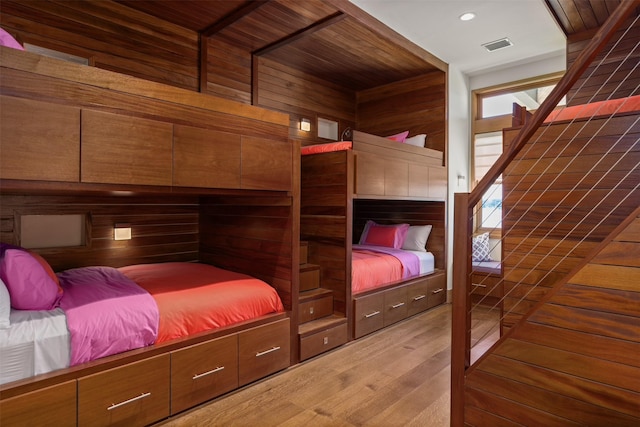 bedroom with wood-type flooring and wood walls