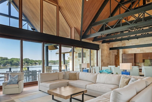 living room with beamed ceiling, a water view, plenty of natural light, and a towering ceiling