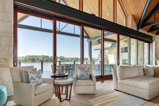 sunroom / solarium featuring a water view and lofted ceiling