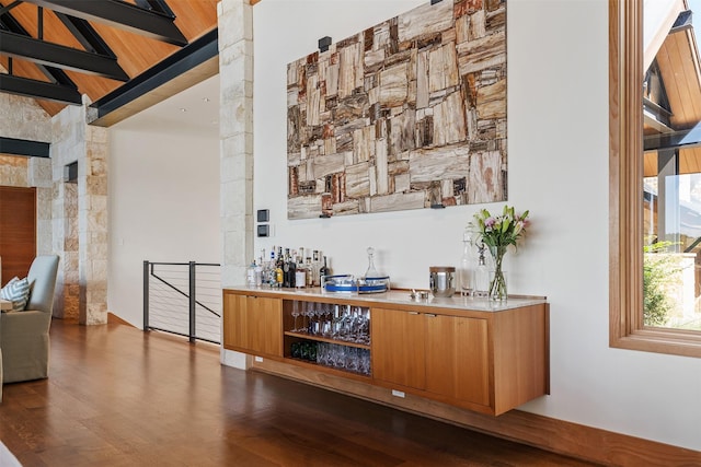 bar with hardwood / wood-style flooring and vaulted ceiling with beams