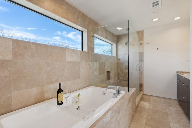 bathroom featuring vanity and independent shower and bath