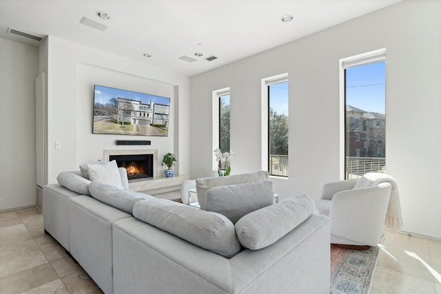 living room featuring light tile patterned flooring and a high end fireplace