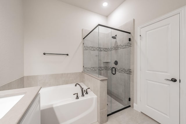 full bath featuring a stall shower, tile patterned flooring, a bath, and vanity