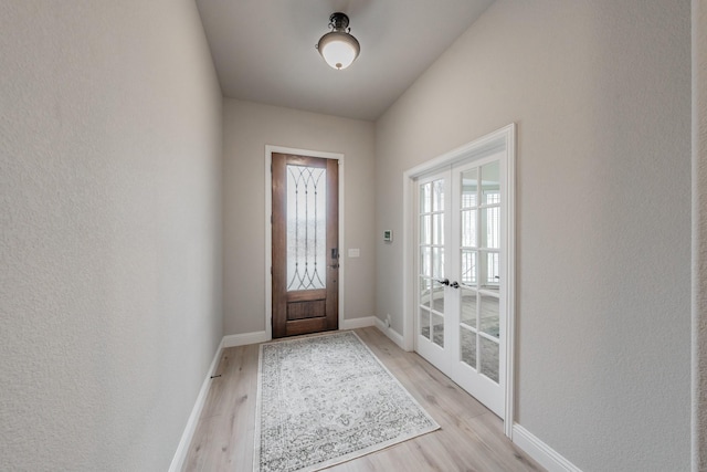 entryway with baseboards and light wood finished floors