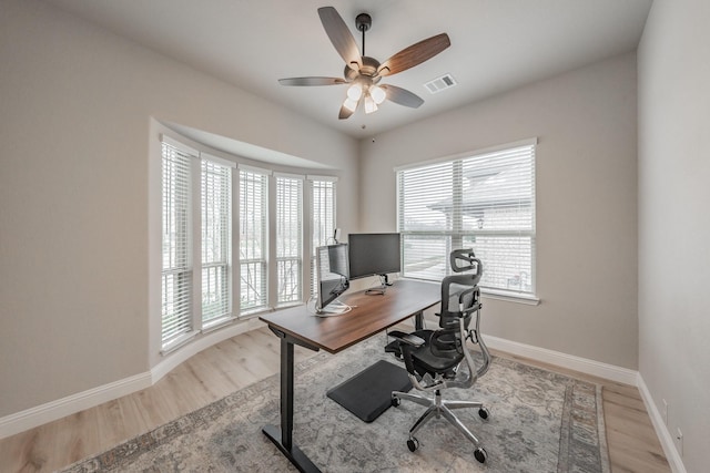 office with a ceiling fan, baseboards, visible vents, and wood finished floors