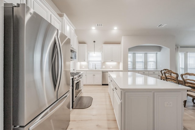 kitchen with light countertops, appliances with stainless steel finishes, a sink, and visible vents