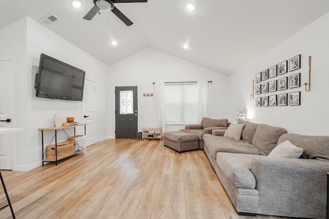 living room with light hardwood / wood-style flooring, ceiling fan, and vaulted ceiling