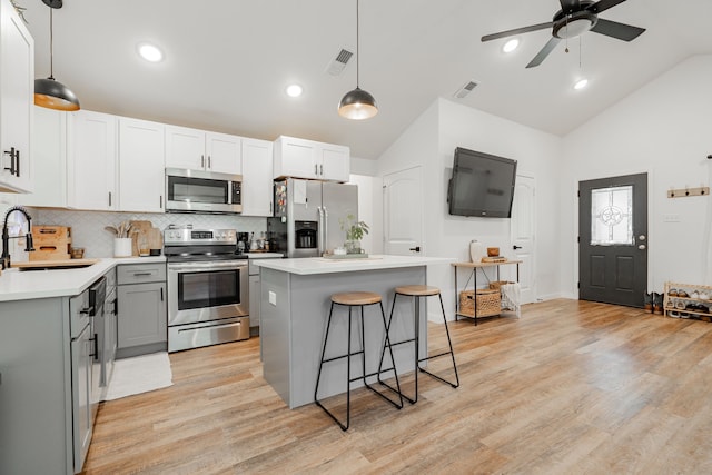 kitchen with a kitchen island, appliances with stainless steel finishes, sink, gray cabinetry, and hanging light fixtures