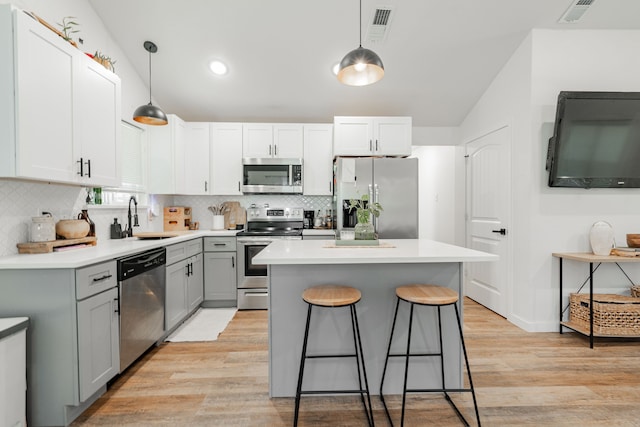 kitchen with pendant lighting, sink, a breakfast bar area, stainless steel appliances, and a center island