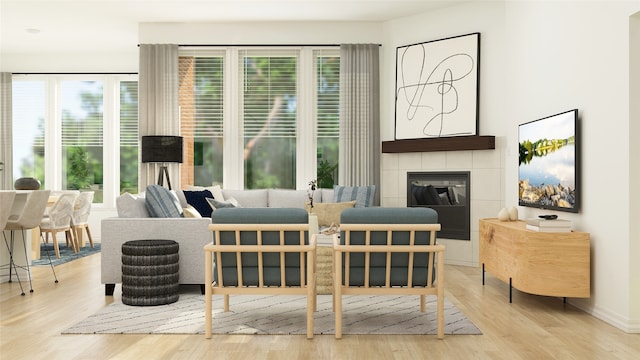 living area with light wood-type flooring, a tile fireplace, and a wealth of natural light