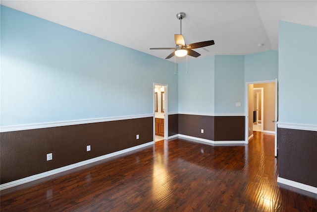 empty room featuring vaulted ceiling, dark wood-type flooring, and ceiling fan