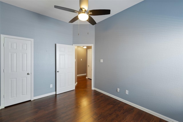 unfurnished bedroom with ceiling fan and dark hardwood / wood-style flooring