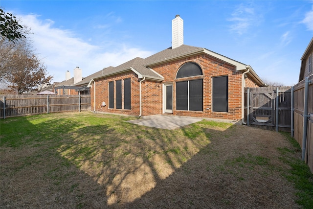 back of property with a yard and a patio area