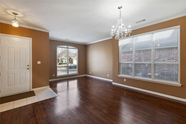 entrance foyer with hardwood / wood-style flooring, crown molding, and a chandelier