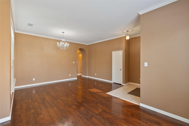 spare room with crown molding, hardwood / wood-style flooring, and an inviting chandelier