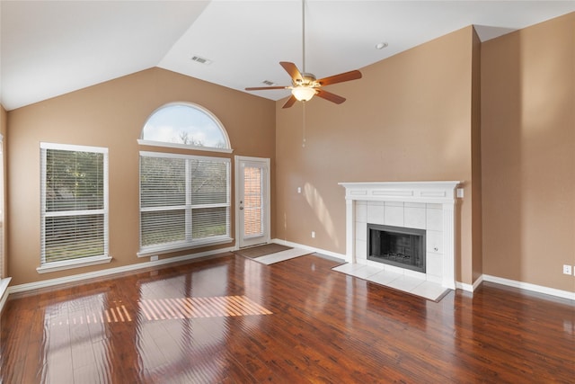 unfurnished living room featuring a tiled fireplace, high vaulted ceiling, hardwood / wood-style floors, and ceiling fan