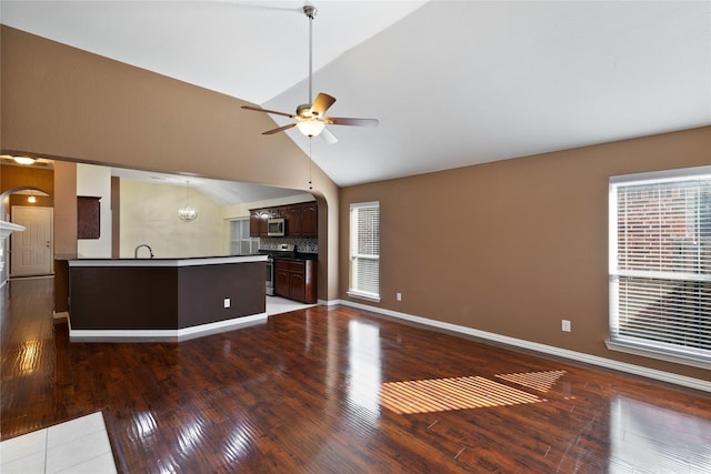 interior space with appliances with stainless steel finishes, wood-type flooring, lofted ceiling, ceiling fan, and dark brown cabinets