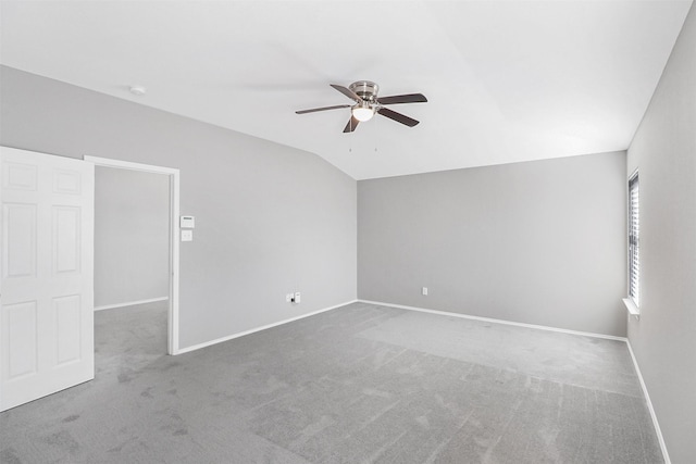 unfurnished room featuring lofted ceiling, ceiling fan, and carpet flooring