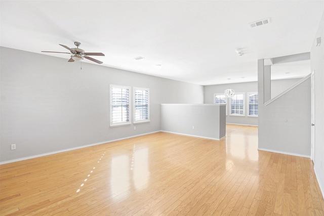 empty room with ceiling fan, a healthy amount of sunlight, and light wood-type flooring