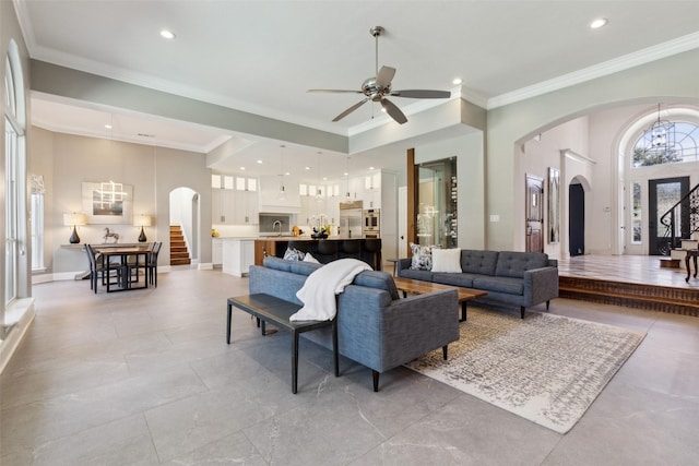 living room with crown molding, sink, and ceiling fan