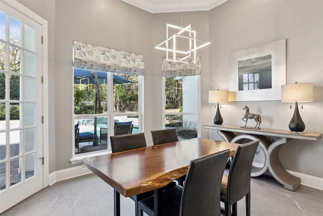 dining area with a high ceiling, ornamental molding, and a chandelier