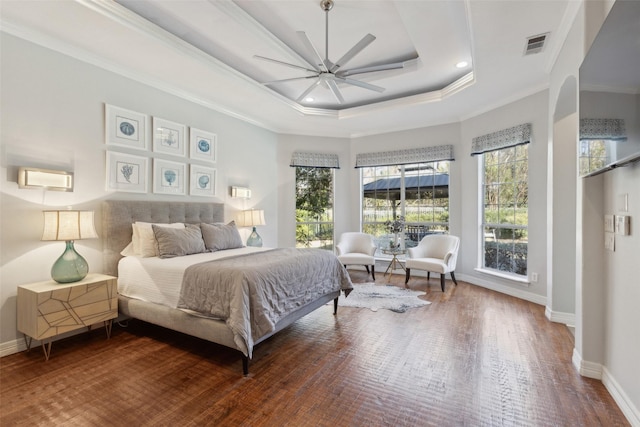 bedroom featuring crown molding, a raised ceiling, ceiling fan, and hardwood / wood-style flooring