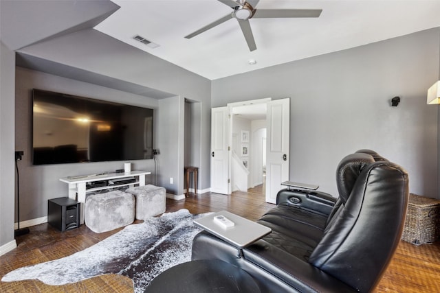 living room featuring dark wood-type flooring and ceiling fan