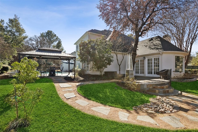 rear view of house with a gazebo, a yard, a patio area, and french doors